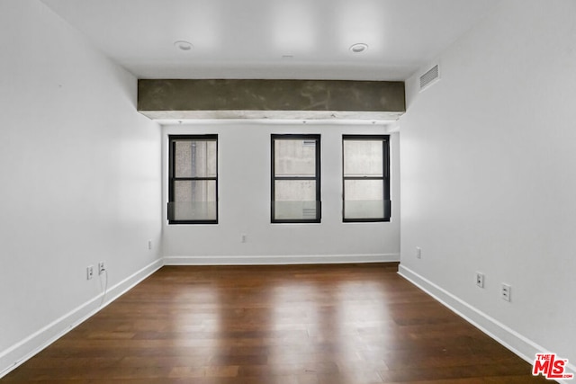 unfurnished room with a wealth of natural light and dark wood-type flooring