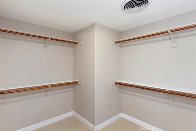 walk in closet featuring light carpet