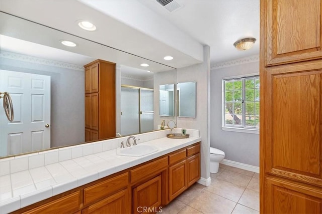 bathroom with a shower with shower door, tile patterned floors, toilet, and vanity