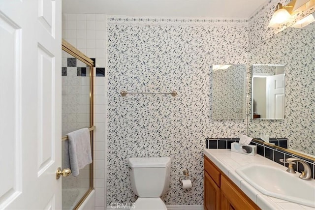 full bathroom featuring bath / shower combo with glass door, toilet, and vanity