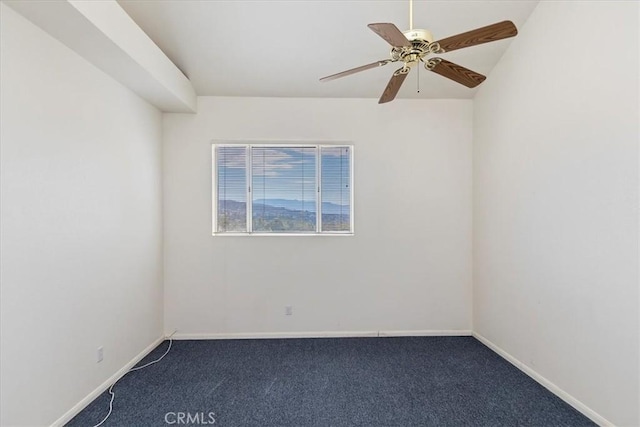 empty room featuring ceiling fan and dark colored carpet