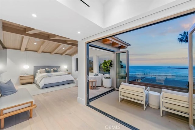 bedroom with vaulted ceiling with beams, wood-type flooring, and a water view