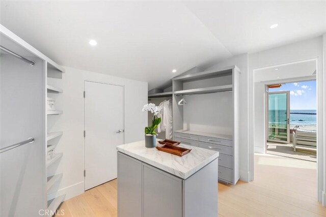 walk in closet featuring lofted ceiling and light hardwood / wood-style flooring