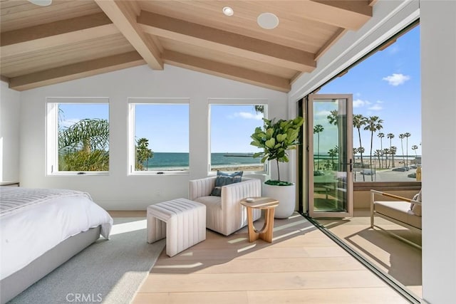 bedroom with light hardwood / wood-style flooring, access to outside, lofted ceiling with beams, and a water view