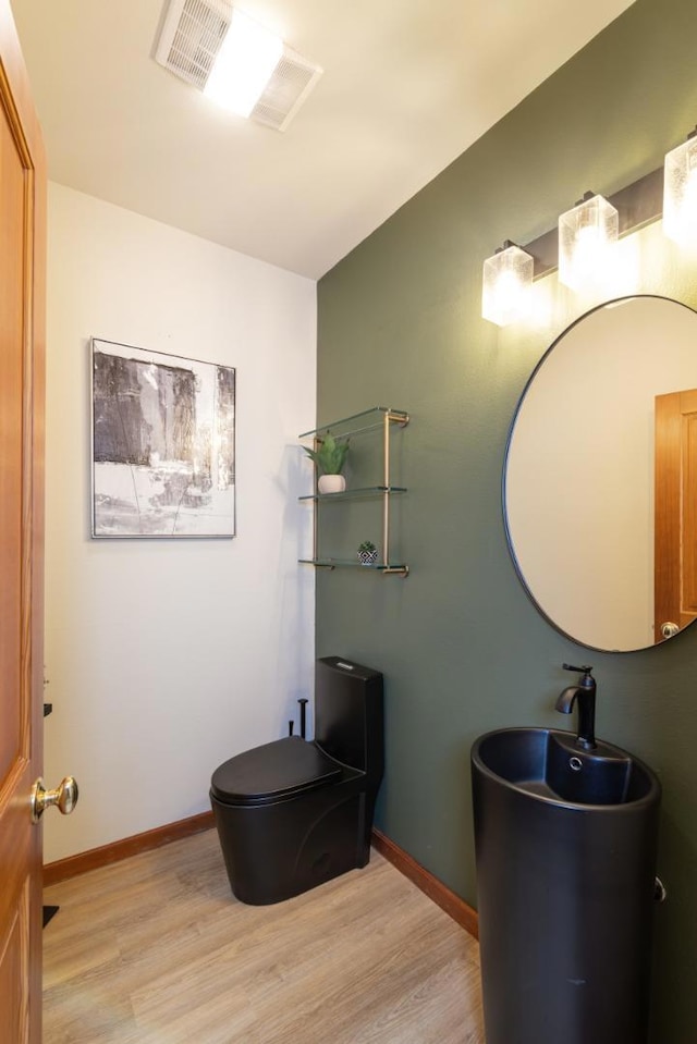 bathroom featuring hardwood / wood-style flooring and toilet