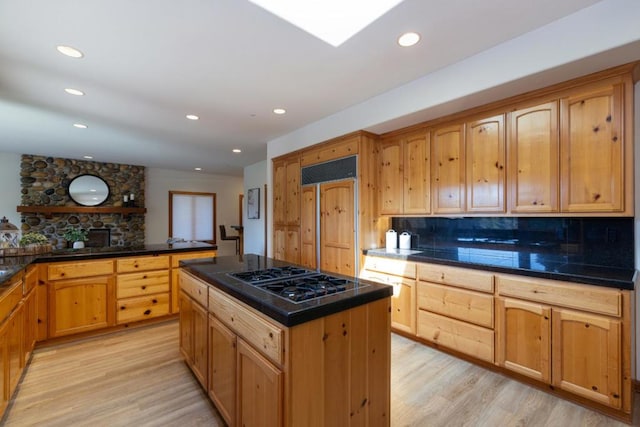 kitchen featuring backsplash, a center island, light hardwood / wood-style floors, and gas stovetop