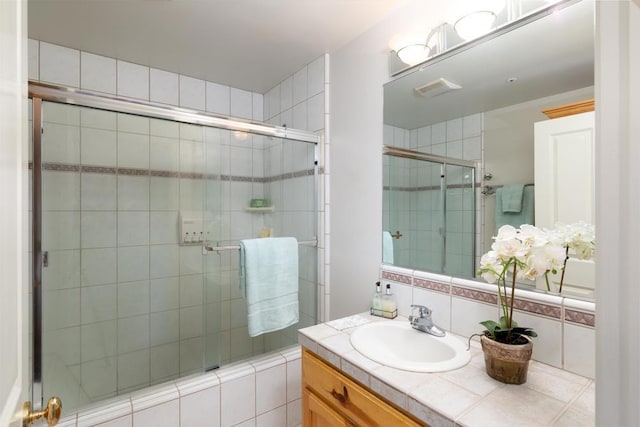 bathroom with vanity and a shower with shower door