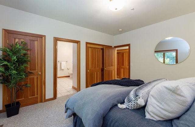 bedroom featuring connected bathroom, light carpet, and a closet