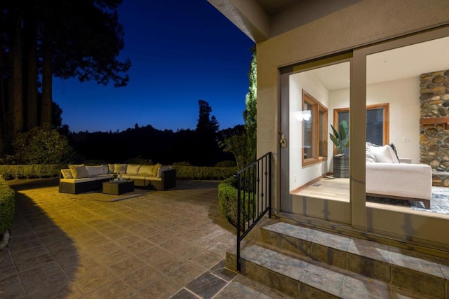 patio at night featuring outdoor lounge area