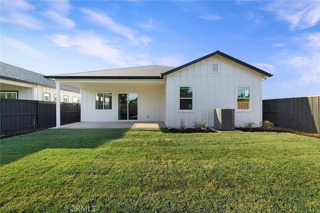 rear view of house with central AC unit, a yard, and a patio area