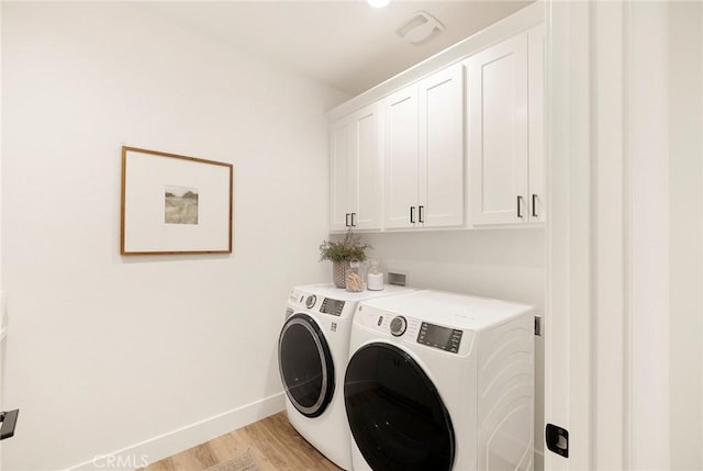 laundry room with cabinets, separate washer and dryer, and light hardwood / wood-style flooring