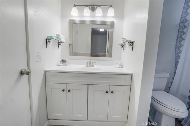 bathroom with walk in shower, vanity, and toilet