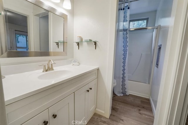 full bathroom with shower / bath combination with glass door, hardwood / wood-style flooring, vanity, and toilet