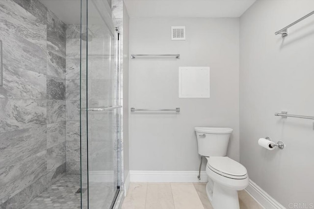 bathroom with toilet, a shower with door, and tile patterned flooring