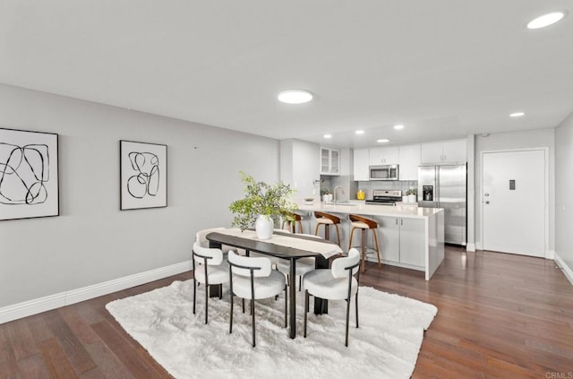 dining space with dark hardwood / wood-style flooring and sink