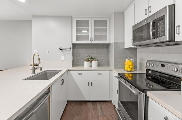 kitchen featuring stainless steel appliances, backsplash, white cabinets, and sink