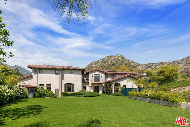 mediterranean / spanish house with a mountain view and a front lawn