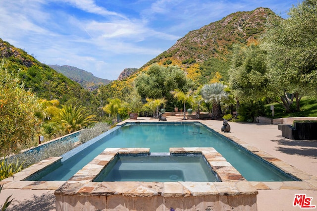 view of swimming pool featuring an in ground hot tub and a mountain view