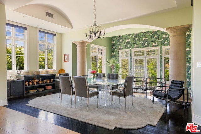 dining room with a notable chandelier, french doors, dark wood-type flooring, and decorative columns