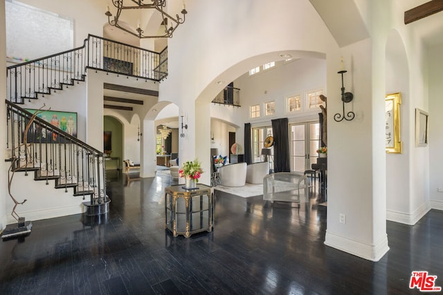 foyer entrance with french doors, dark wood-type flooring, and a high ceiling