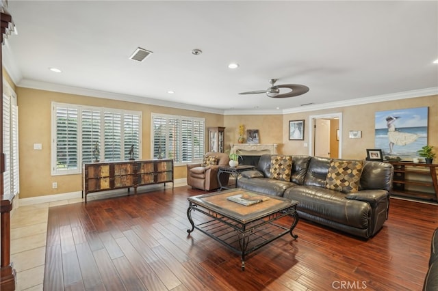 living room featuring a healthy amount of sunlight, ornamental molding, and hardwood / wood-style flooring