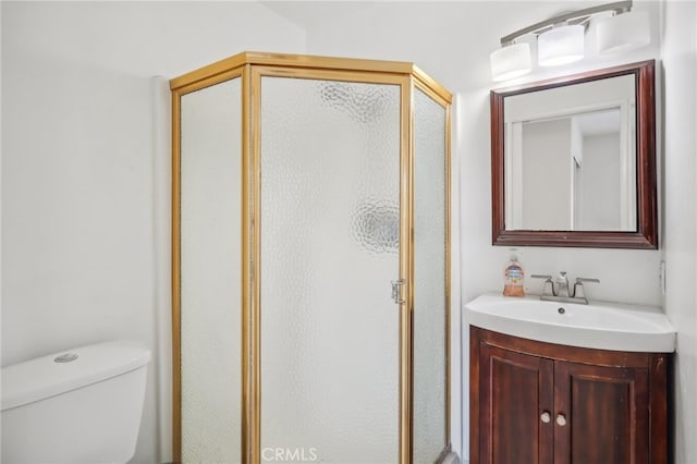 bathroom with vanity, toilet, and a shower with shower door