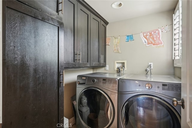 washroom with cabinets and washing machine and clothes dryer