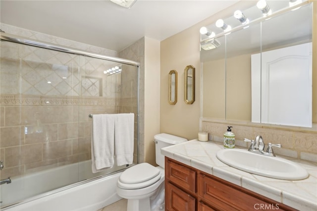 full bathroom featuring shower / bath combination with glass door, vanity, and toilet