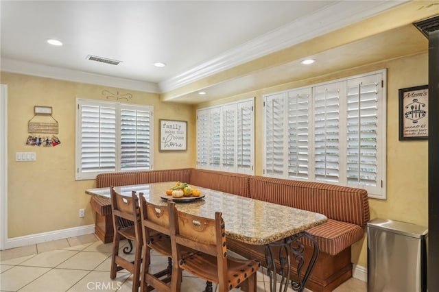 dining area with breakfast area, light tile patterned floors, and crown molding