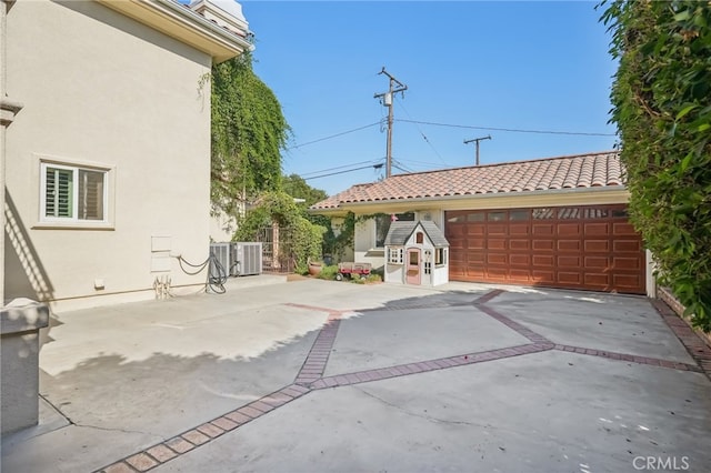 view of patio with central AC unit and a garage