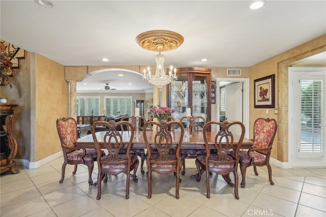 dining space with ceiling fan with notable chandelier, light tile patterned floors, and ornate columns