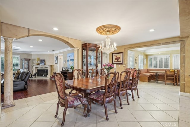 dining space with an inviting chandelier, crown molding, light hardwood / wood-style floors, and a wealth of natural light