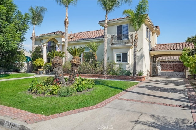 mediterranean / spanish-style home featuring a balcony and a front yard