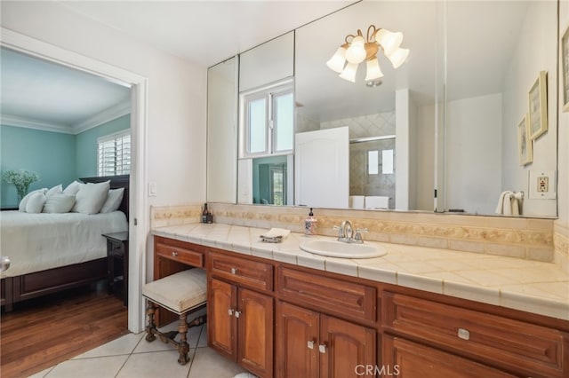 bathroom featuring vanity, a shower with shower door, ornamental molding, and plenty of natural light