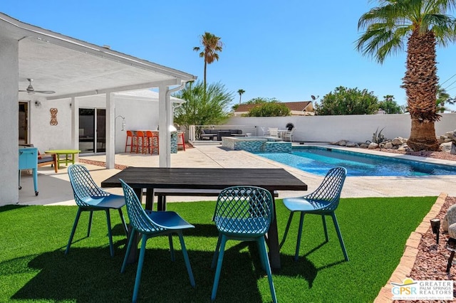 view of pool featuring a lawn, a deck, a bar, and an in ground hot tub