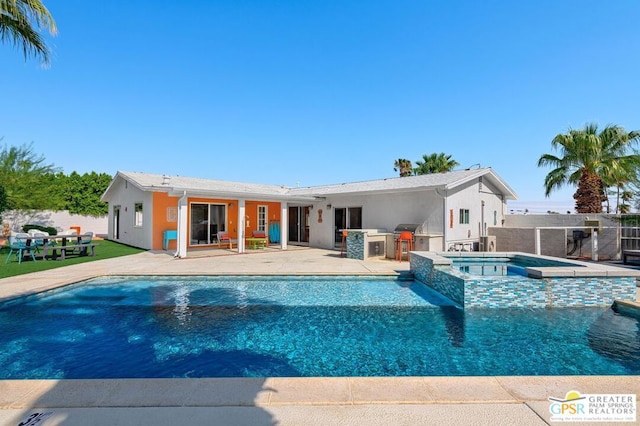 view of pool featuring a patio area, exterior kitchen, and an in ground hot tub