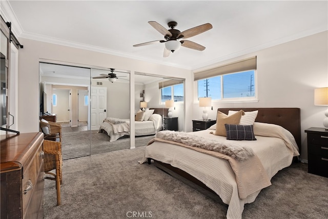 carpeted bedroom with multiple closets, ornamental molding, a barn door, and ceiling fan