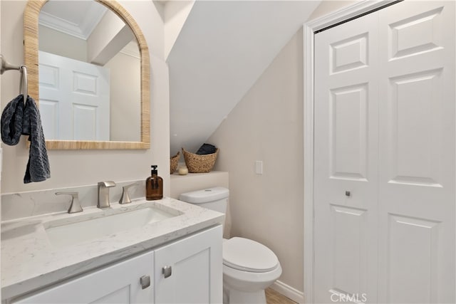 bathroom featuring vanity, toilet, and ornamental molding