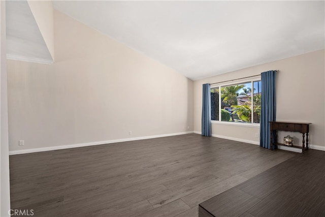 unfurnished living room featuring vaulted ceiling and dark hardwood / wood-style flooring