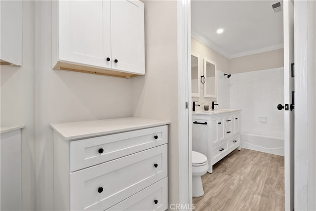 full bathroom with wood-type flooring, shower / bathing tub combination, toilet, vanity, and crown molding