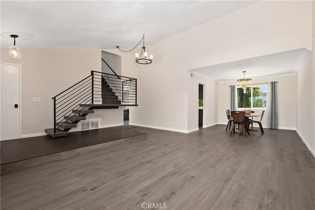 unfurnished living room featuring crown molding, a notable chandelier, and hardwood / wood-style floors