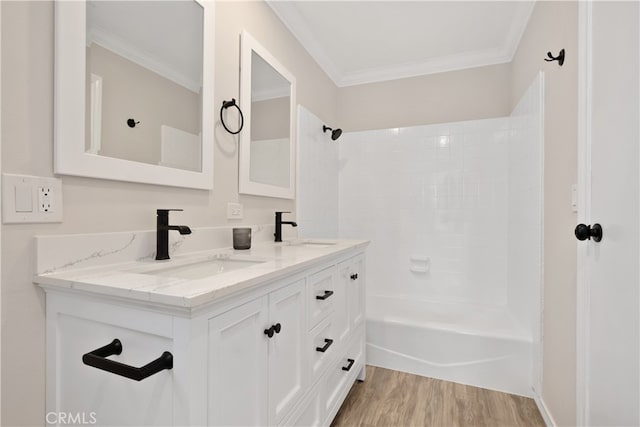 bathroom with vanity, shower / washtub combination, hardwood / wood-style flooring, and crown molding