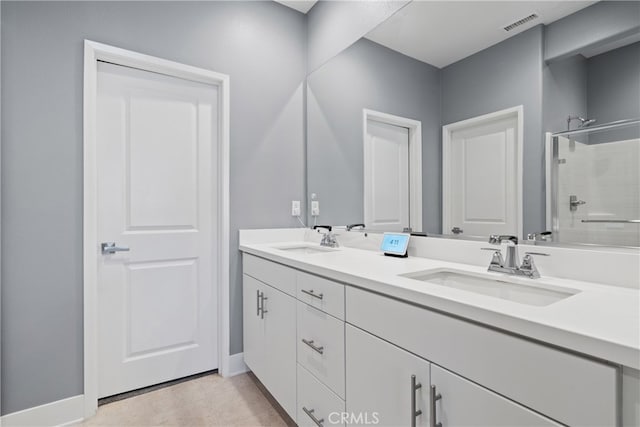 bathroom with tile patterned floors, a shower, and vanity