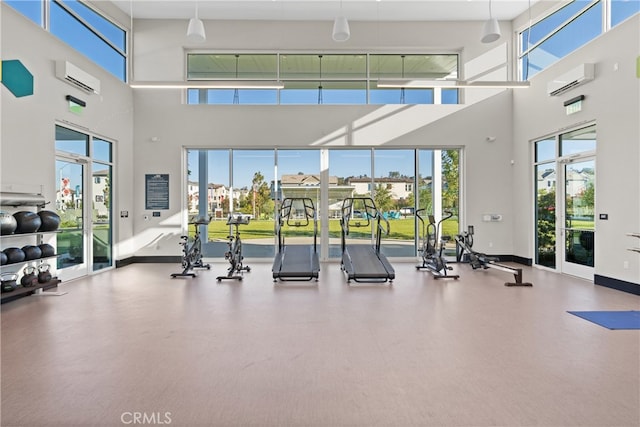 gym with a high ceiling and a wall mounted air conditioner