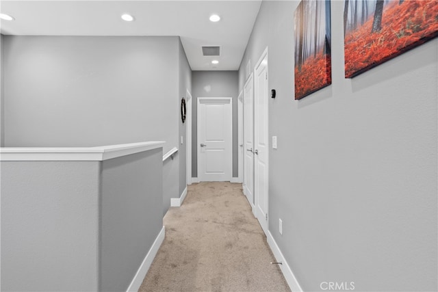 hall featuring light colored carpet