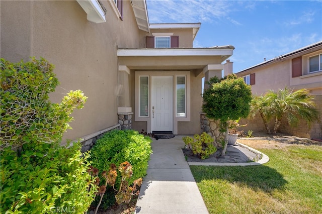 doorway to property with a yard