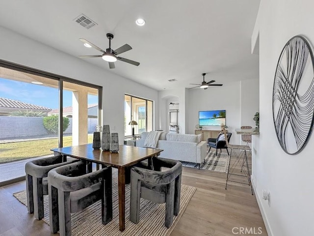 dining space with ceiling fan and light hardwood / wood-style flooring