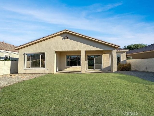 rear view of property featuring a patio area and a yard