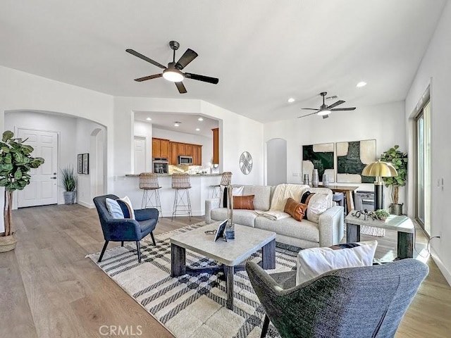 living room featuring light hardwood / wood-style floors and ceiling fan