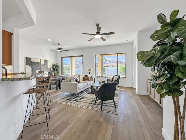 living room with ceiling fan and light wood-type flooring